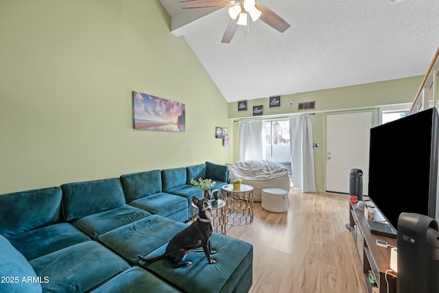 living room featuring light wood finished floors, visible vents, ceiling fan, a textured ceiling, and high vaulted ceiling