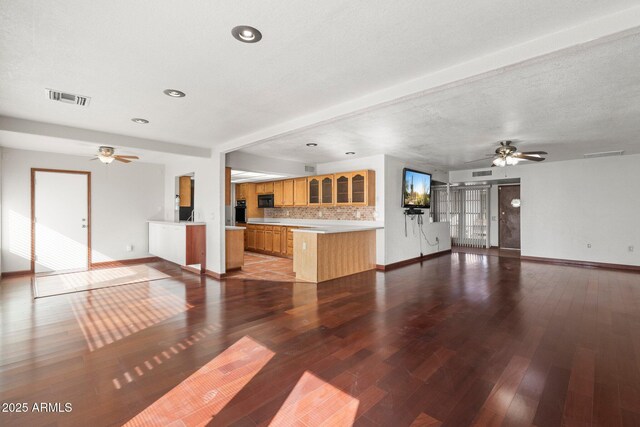 unfurnished living room with hardwood / wood-style floors, a textured ceiling, and ceiling fan