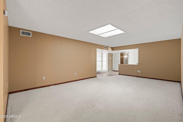 unfurnished room with light colored carpet and a textured ceiling