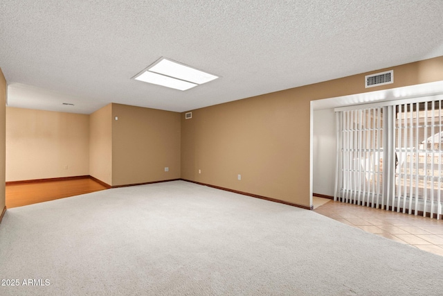 carpeted spare room with a textured ceiling