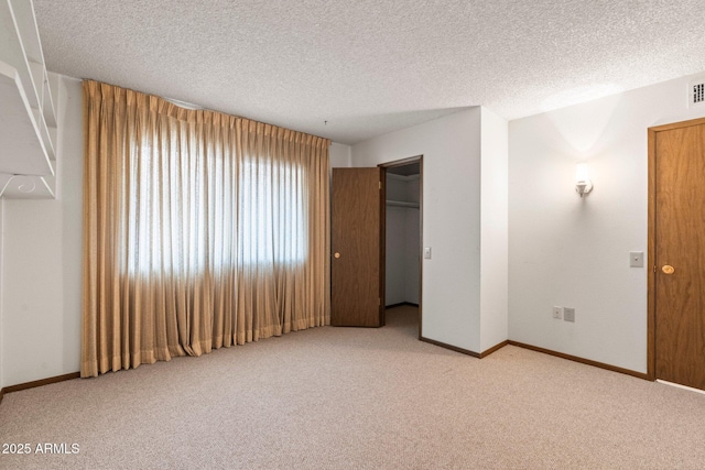 unfurnished bedroom featuring light colored carpet, a closet, and a textured ceiling