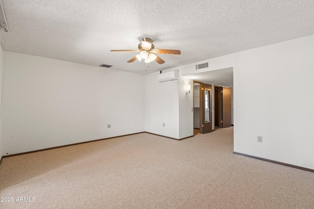 carpeted empty room with ceiling fan, an AC wall unit, and a textured ceiling