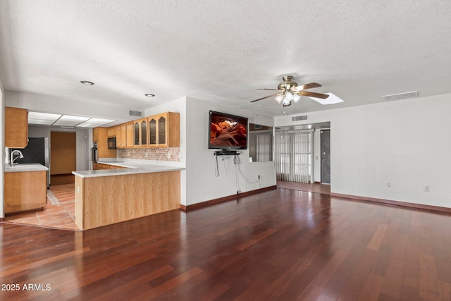 unfurnished living room featuring hardwood / wood-style floors, a textured ceiling, and ceiling fan