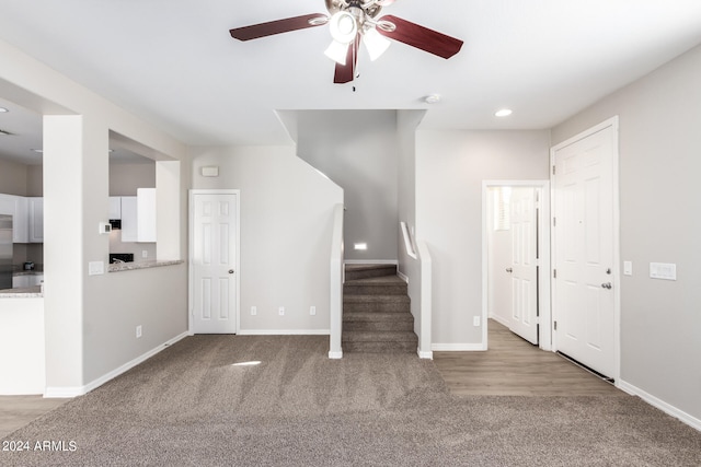 unfurnished living room featuring ceiling fan and light carpet