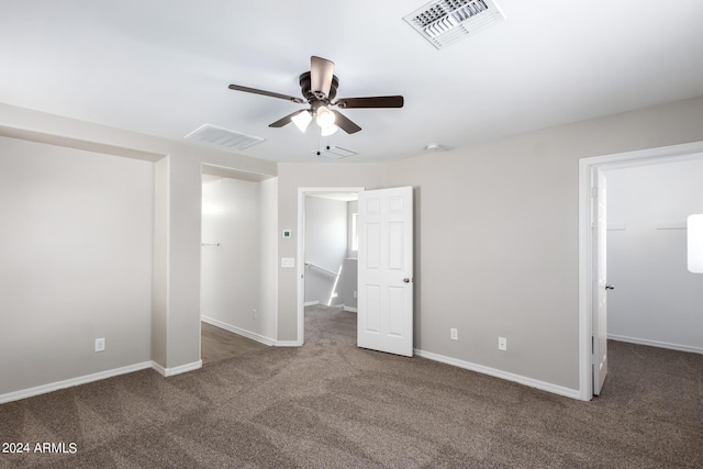 unfurnished bedroom with carpet flooring, a walk in closet, baseboards, visible vents, and ceiling fan