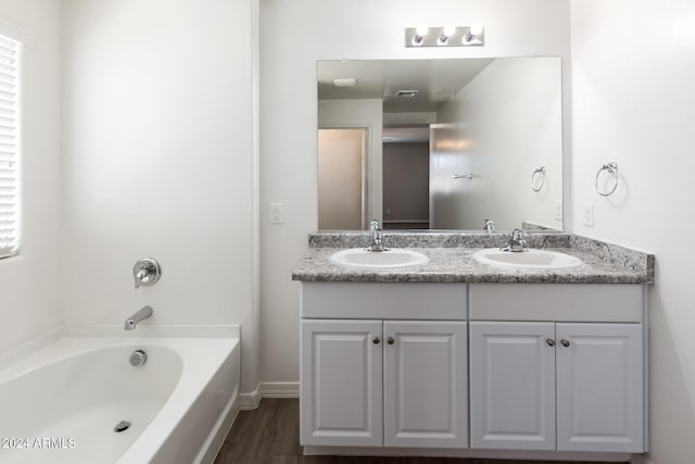 bathroom featuring vanity, hardwood / wood-style floors, and a tub