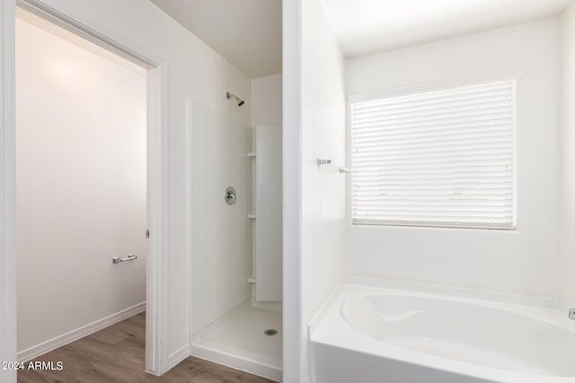 bathroom featuring wood-type flooring and plus walk in shower