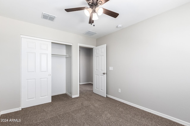 unfurnished bedroom featuring ceiling fan, dark colored carpet, and a closet