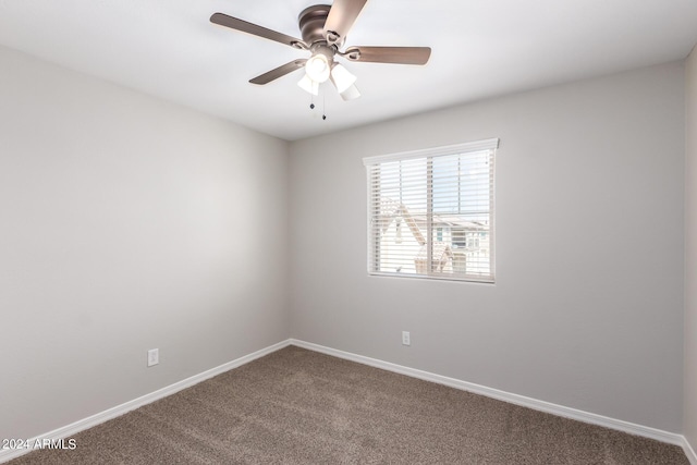 spare room with a ceiling fan, carpet, and baseboards