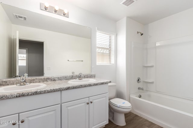 bathroom featuring double vanity, visible vents, toilet, and a sink
