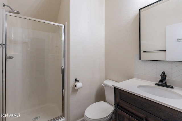 bathroom with vanity, toilet, tasteful backsplash, and a shower with door