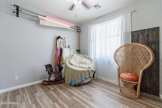 living area with ceiling fan and light hardwood / wood-style floors