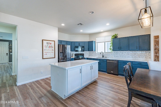 kitchen featuring light wood finished floors, light countertops, decorative backsplash, blue cabinets, and black appliances