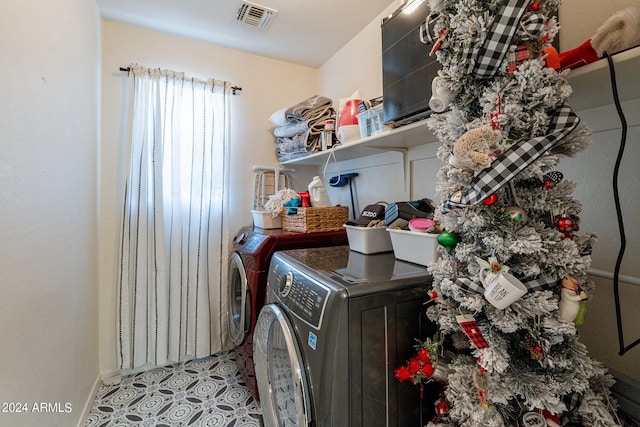 laundry area with washer and dryer and light tile patterned floors