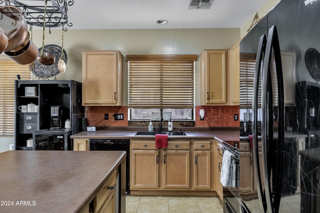 kitchen featuring light brown cabinets, black appliances, sink, decorative backsplash, and light tile patterned floors