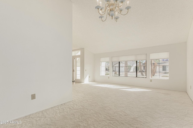 unfurnished living room featuring a notable chandelier, vaulted ceiling, carpet floors, and a textured ceiling