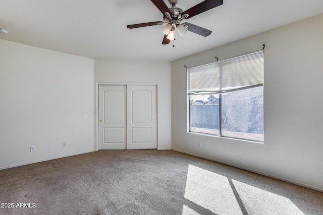 unfurnished bedroom featuring a closet, carpet flooring, and a ceiling fan