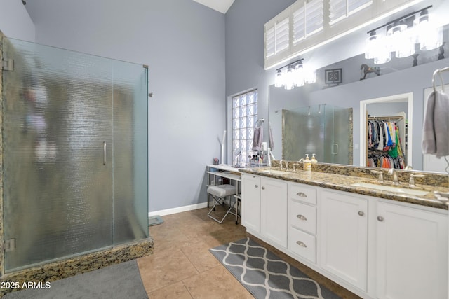 bathroom with an enclosed shower, vanity, a towering ceiling, and tile patterned floors