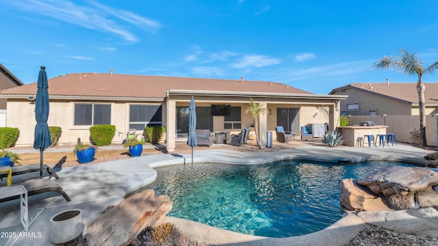 view of swimming pool featuring a patio and exterior bar