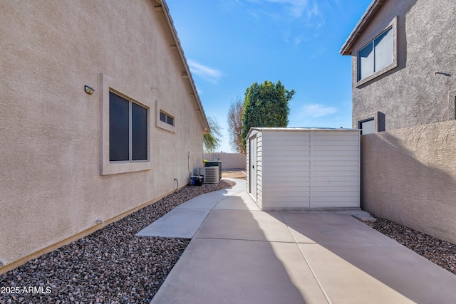 view of home's exterior featuring a patio area, cooling unit, and a storage unit