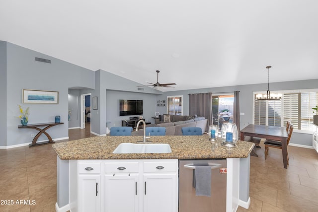 kitchen featuring vaulted ceiling, pendant lighting, sink, a kitchen island with sink, and white cabinets