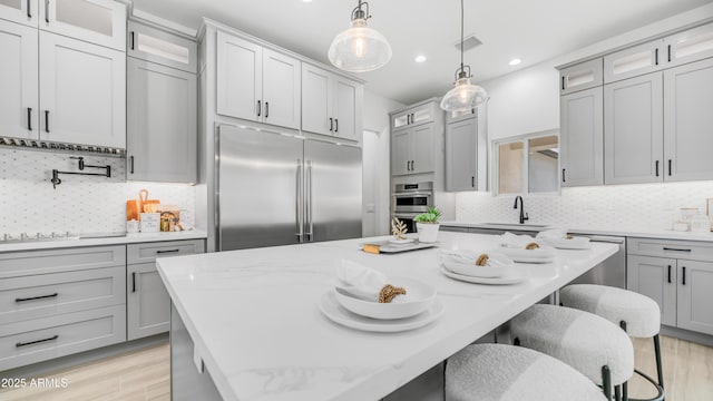 25916 S 198th St, Queen Creek, AZ 85142 - kitchen featuring glass insert cabinets, a sink, a breakfast bar, stainless steel appliances, and tasteful backsplash