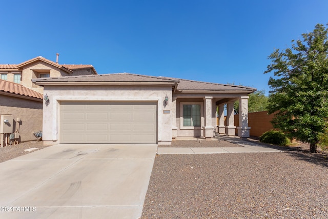 view of front of house featuring a garage, concrete driveway, a tile roof, and stucco siding