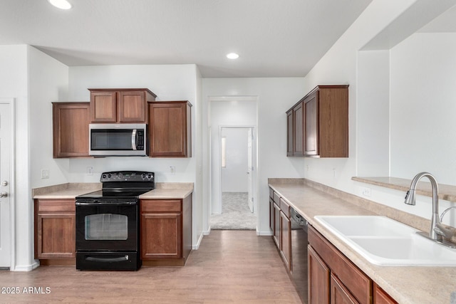 26058 W Yukon Dr, Buckeye, AZ 85396 - kitchen featuring stainless steel appliances, a sink, light wood-style floors, light countertops, and recessed lighting