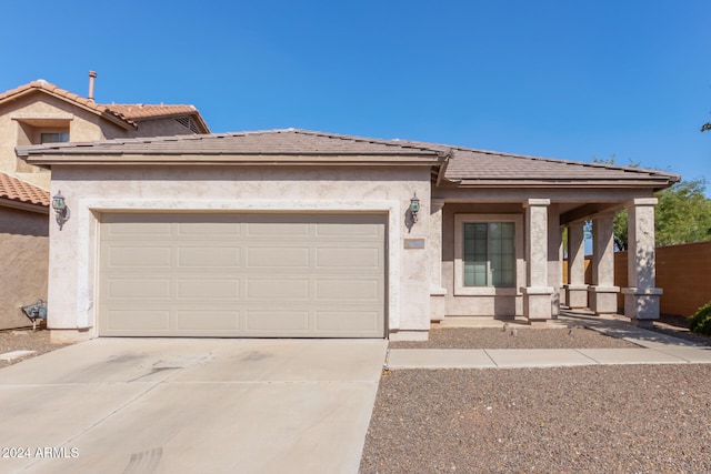 view of front of property with a garage, a tile roof, concrete driveway, and stucco siding