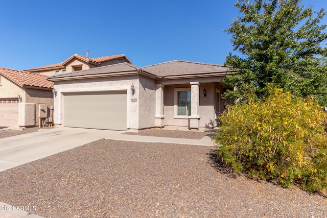 view of front facade with driveway, an attached garage, a tile roof, and stucco siding