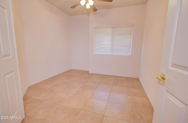 spare room with ceiling fan and light tile patterned floors