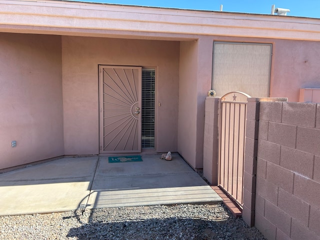 view of exterior entry with a patio