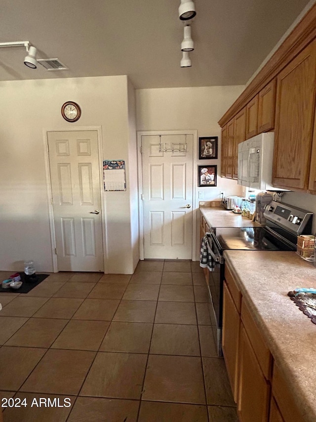 kitchen featuring dark tile patterned floors and range with electric stovetop