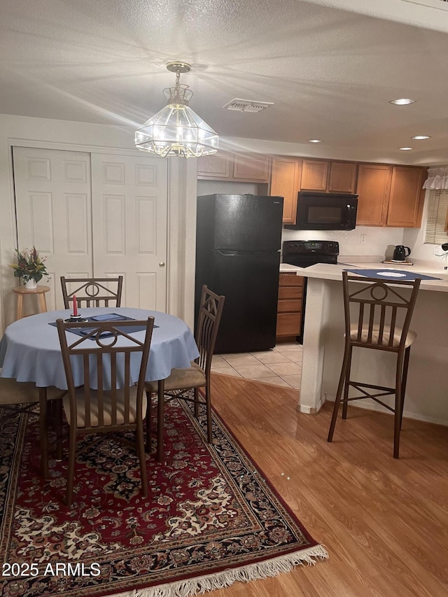 dining area featuring light wood-type flooring, visible vents, and recessed lighting