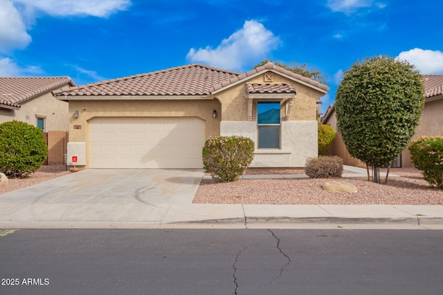 mediterranean / spanish home with stucco siding, a garage, concrete driveway, and a tiled roof