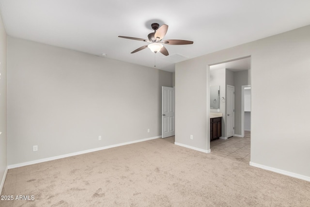 unfurnished bedroom featuring visible vents, connected bathroom, baseboards, ceiling fan, and light carpet