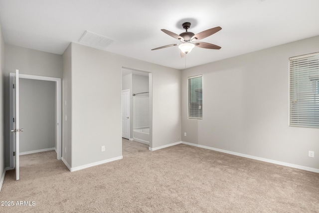 unfurnished bedroom with visible vents, baseboards, ceiling fan, ensuite bathroom, and light colored carpet