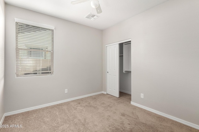 unfurnished bedroom with visible vents, a closet, carpet floors, baseboards, and ceiling fan