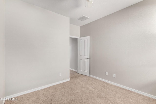 carpeted spare room with visible vents and baseboards