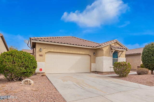 mediterranean / spanish house with stucco siding, a tiled roof, concrete driveway, and a garage