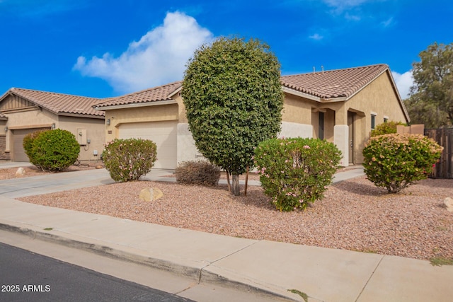 view of front of property featuring fence, driveway, an attached garage, stucco siding, and a tiled roof