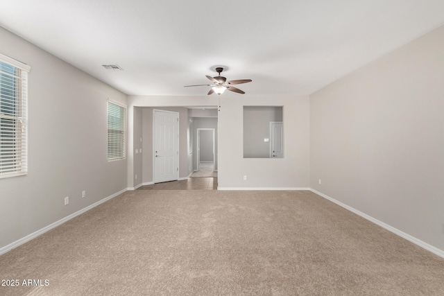 spare room featuring carpet flooring, baseboards, visible vents, and ceiling fan