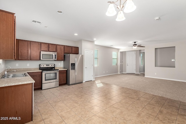 kitchen with visible vents, a sink, stainless steel appliances, light countertops, and light colored carpet