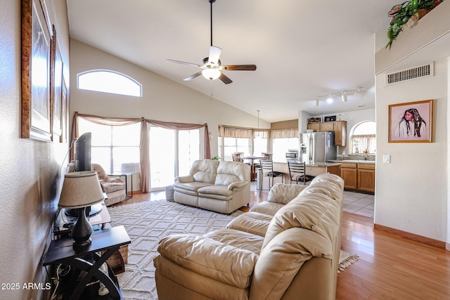 living room featuring light wood-type flooring, ceiling fan, and high vaulted ceiling