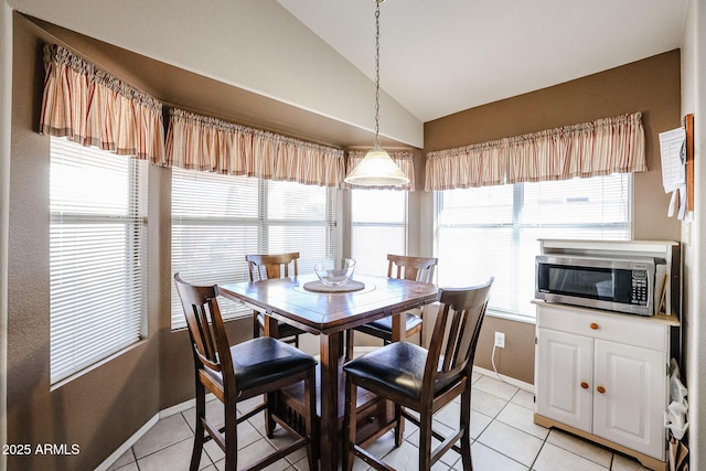 tiled dining area with lofted ceiling