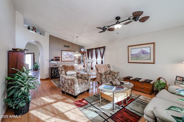 living room featuring ceiling fan with notable chandelier, light hardwood / wood-style flooring, and lofted ceiling