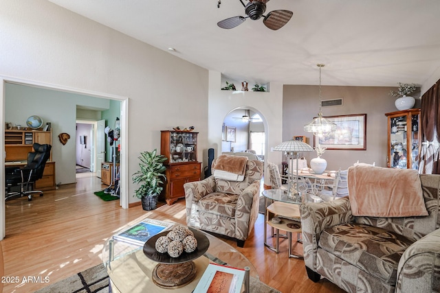 living room with ceiling fan, vaulted ceiling, and light hardwood / wood-style flooring