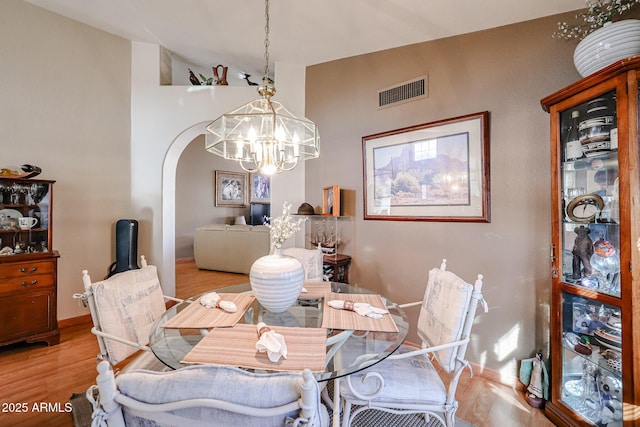 dining area with light hardwood / wood-style flooring and a notable chandelier