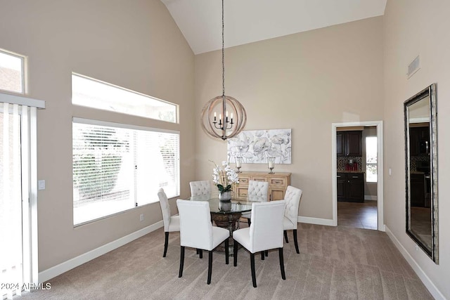 carpeted dining area featuring a wealth of natural light, high vaulted ceiling, and an inviting chandelier