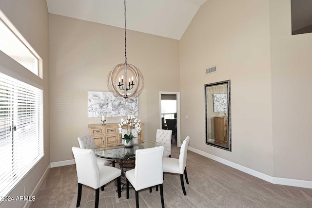 dining room with carpet flooring, high vaulted ceiling, and a chandelier